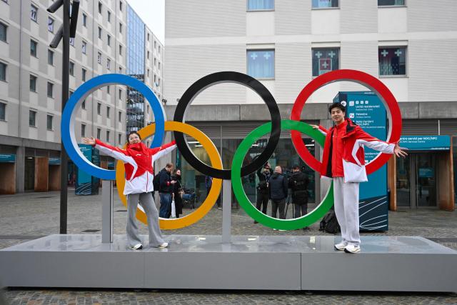 Team China's figure skaters Wang Shiyue (L) and Liu Xiunyu pose with the Olympic rings at the Olympic Village ahead of the Milano Cortina 2026 Winter Olympics in Milan on February 3, 2026. (Photo by PIERO CRUCIATTI / AFP)