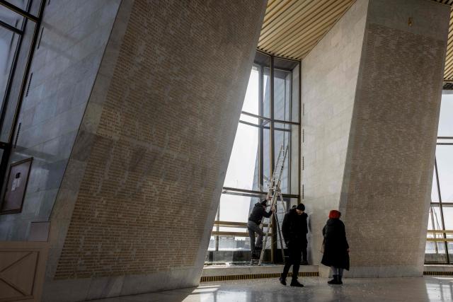 People stand near damaged windows following a Russian strike in The National Museum of the History of Ukraine in the Second World War in Kyiv on February 3, 2026, amid the Russian invasion of Ukraine. (Photo by Tetiana DZHAFAROVA / AFP)