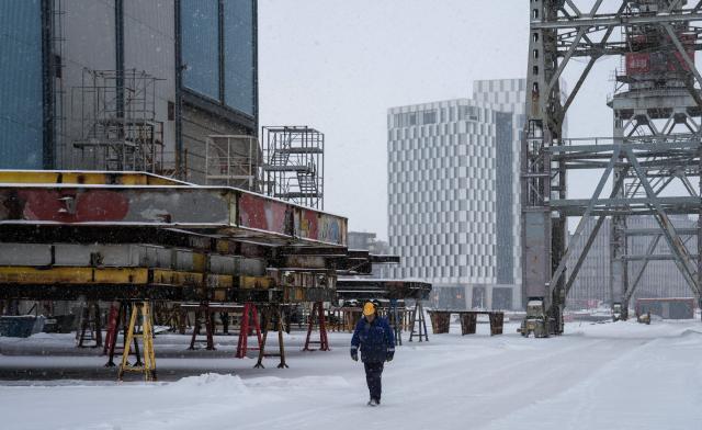 A worker walks at the premises of Helsinki Shipyard on January 28, 2026 in Helsinki, Finland. Finland is building a new fleet of icebreakers for the US but the US President plans for Greenland, which he covets, and tense US-EU ties have raised concerns over the deal. (Photo by Alessandro RAMPAZZO / AFP)