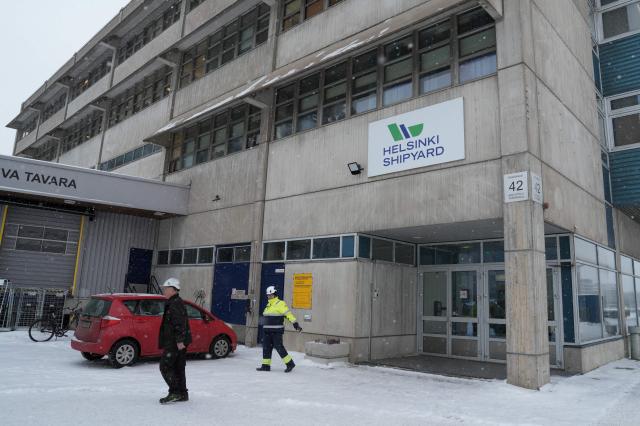 Workers walk at the premises of Helsinki Shipyard on January 28, 2026 in Helsinki, Finland. Finland is building a new fleet of icebreakers for the US but the US President plans for Greenland, which he covets, and tense US-EU ties have raised concerns over the deal. (Photo by Alessandro RAMPAZZO / AFP) / TO GO WITH AFP STORY BY Anna KORKMAN
