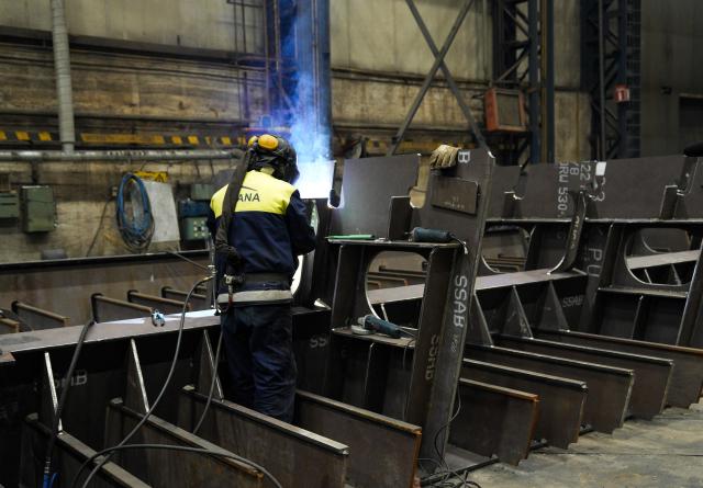 A shipyard employee works on an icebreaker structure in one of the halls of Helsinki Shipyard on January 28, 2026 in Helsinki, Finland. Finland is building a new fleet of icebreakers for the US but the US President's plans for Greenland, which he covets, and tense US-EU ties have raised concerns over the deal. Sixty percent of the world's icebreakers are Finnish-made and 80 percent are designed by Finnish companies, according to Arctia, the state-owned firm which manages the country's icebreaker fleet. (Photo by Alessandro RAMPAZZO / AFP)