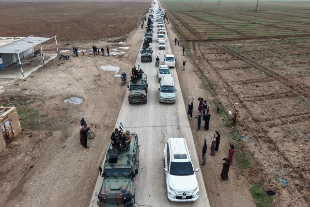 An aerial photograph shows Syrian government forces driving along a road as they enter the Kurdish-majority city of Qamishli on February 3, 2026. Syrian government forces started entering Qamishli on February 3, under an integration deal agreed with the Kurds last week, state media reported. The move comes after security personnel entered the mixed Kurdish-Arab city of Hasakeh and the countryside around the Kurdish town of Kobane a day earlier, as part of the comprehensive agreement to gradually integrate Kurdish forces and institutions into the state. (Photo by Bakr ALKASEM / AFP)