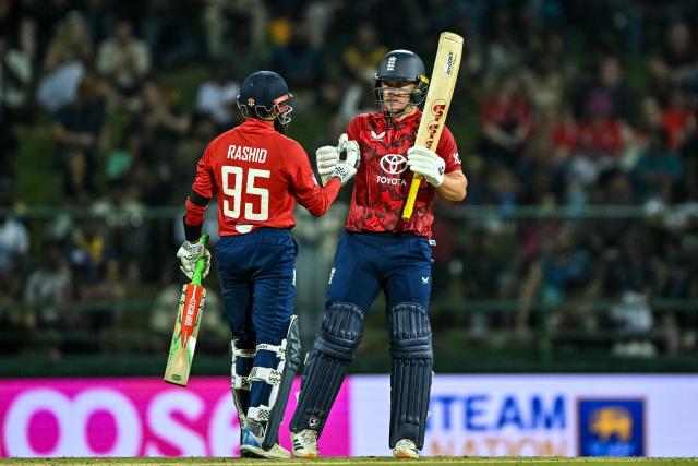 England's Sam Curran (R) celebrates with teammate Adil Rashid after scoring a half-century (50 runs) during the third and final Twenty20 international cricket match between Sri Lanka and England at the Pallekele International Cricket Stadium in Kandy on February 3, 2026. (Photo by Ishara S. KODIKARA / AFP)
