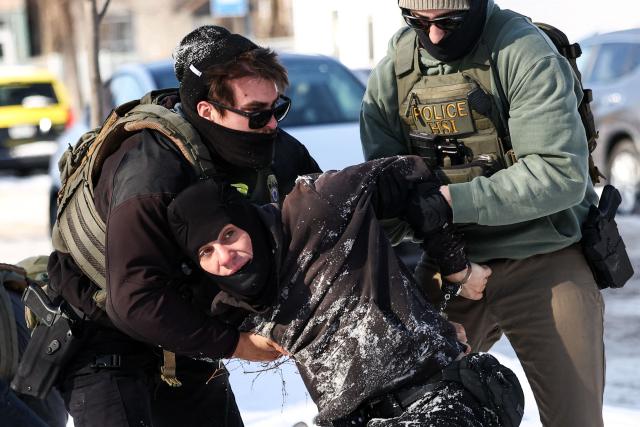 Federal agents detain a protester in Minneapolis, Minnesota on February 3, 2026. A US judge on January 31, 2026 denied Minnesota's bid to force Immigration and Customs Enforcement (ICE) to suspend its sweeping detention and deportation operation in the state that has left two US citizens dead and fueled massive protests. Masked and heavily armed federal agents have swept through Minnesota communities seeking undocumented migrants, detaining thousands and shooting dead two US citizens in the process. (Photo by Charly TRIBALLEAU / AFP) / ALTERNATE CROP