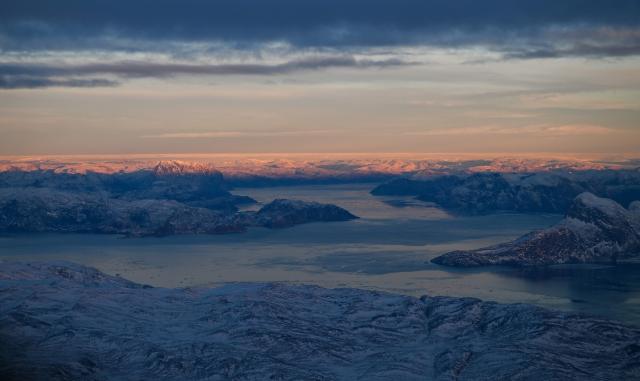 This aerial view taken from an airplane shows a landscape of snow covered mountains along the coastline between Sisimiut and Nuuk, western Greenland, on February 3, 2026. (Photo by Ina FASSBENDER / AFP)