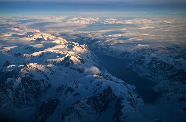 This aerial view taken from an airplane shows a landscape of snow covered mountains along the coastline between Sisimiut and Nuuk, western Greenland, on February 3, 2026. (Photo by Ina FASSBENDER / AFP)