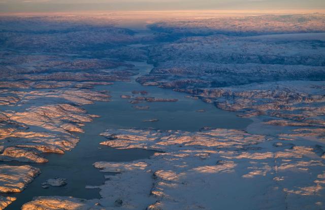 This aerial view taken from an airplane shows a landscape of snow covered mountains along the coastline between Sisimiut and Nuuk, western Greenland, on February 3, 2026. (Photo by Ina FASSBENDER / AFP)