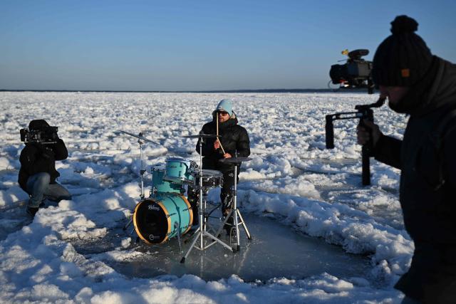 People play drums as they record a music video on the frozen Baltic Sea near Mikoszewo, northern Poland on February 3, 2026. (Photo by Sergei GAPON / AFP)