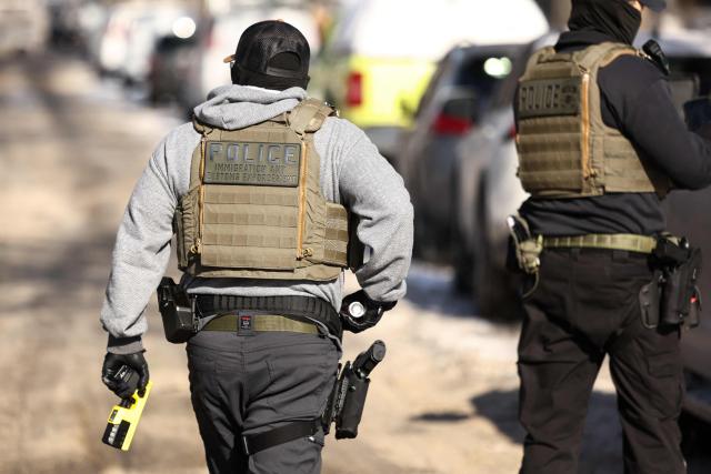 Federal agents are seen during an anti-immigration raid in Minneapolis, Minnesota on February 3, 2026. A US judge on January 31, 2026 denied Minnesota's bid to force Immigration and Customs Enforcement (ICE) to suspend its sweeping detention and deportation operation in the state that has left two US citizens dead and fueled massive protests. Masked and heavily armed federal agents have swept through Minnesota communities seeking undocumented migrants, detaining thousands and shooting dead two US citizens in the process. (Photo by Charly TRIBALLEAU / AFP) / ALTERNATE CROP