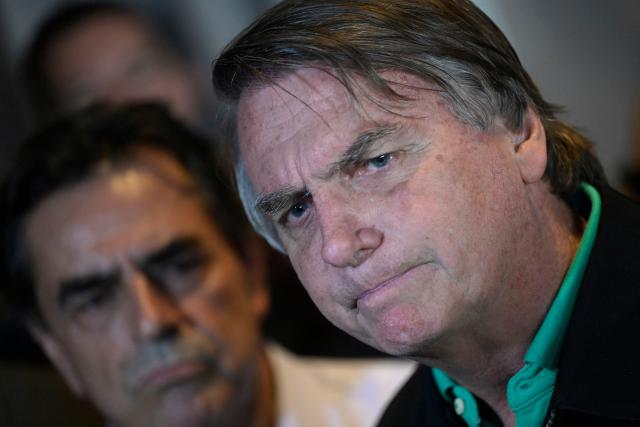 (FILES) Former Brazilian President Jair Bolsonaro speaks to members of the media in Belo Horizonte, Minas Gerais state, Brazil, on June 30, 2023. In an unprecedented case for Brazil, a military tribunal announced on February 4, 2026, that it would examine whether to strip former president Jair Bolsonaro of his rank, along with several generals who were all convicted with an attempted coup. (Photo by Douglas Magno / AFP)
