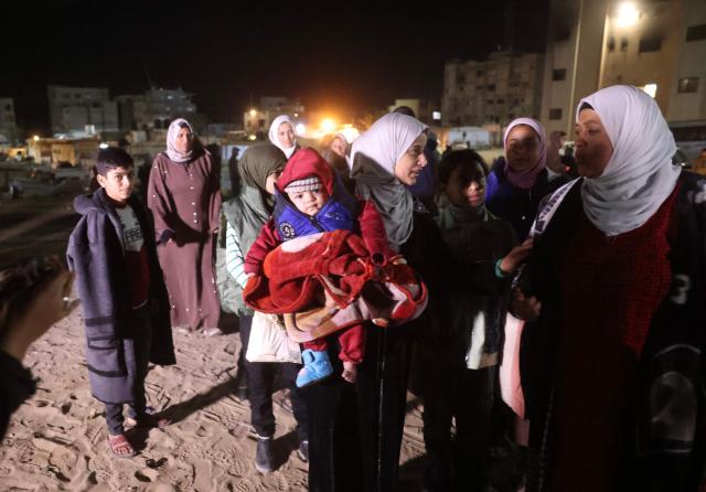 Palestinians, coming from the Rafah crossing with Egypt, arrive at Nasser Hospital in Khan Yunis in the southern Gaza Strip on February 4, 2026. Gazans long-separated from their loved ones shed tears of joy after the limited reopening of the Rafah crossing with Egypt allowed a handful to finally return to the war-shattered territory. Jubilant crowds filmed on their phones as they flocked around a bus carrying returnees to Nasser Hospital in the southern city of Khan Yunis late in the night. (Photo by Bashar Taleb / AFP)