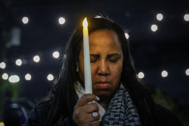 A woman prays during a candlelight vigil for Haitians living in the US under the Temporary Protected Status (TPS) immigration program in Miami, Florida on February 3, 2026. Late on February 2, federal judge Ana C. Reyes of the Federal District Court in Washington, blocked the Trump administration from ending TPS for an estimated 350,000 Haitian immigrants. The status, which offers protection from deportation and work authorization, was set to expire on Feb. 3. (Photo by Giorgio Viera / AFP)