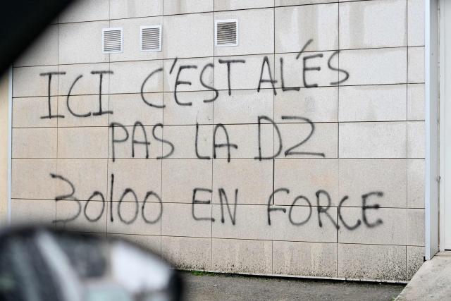 This photograph shows inscriptions on a wall at the Cevennes district in Ales, southern France on January 22, 2026, during a visit of drug dealing spots by French prosecutors. "The street sweeper can no longer come to clean, and at night there is gunfire": for this Alès resident, the arrival of the Marseille-based DZ Mafia criminal group in this small Gard town, as elsewhere in France, makes life increasingly unbearable.

"If the mayor wants us to vote for him in the neighborhood, he has to eradicate this problem", said this woman who requested anonymity just a few weeks before the municipal elections at the foot of her building where tags display the price per gram of cannabis or cocaine. (Photo by Sylvain THOMAS / AFP)