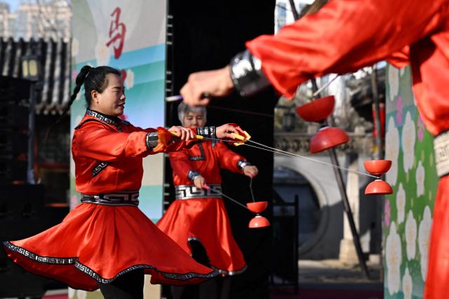 Dancers perform with diabolos during the start of the Spring Culture Festival which falls on the day of Lichun, or the beginning of the first of the 24 solar terms in the Chinese calendar, at the Ancient Observatory building in Beijing on February 4, 2026. (Photo by Adek BERRY / AFP)