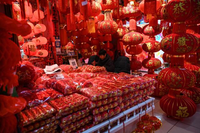 A vendor waits for customers at a lantern stall ahead of the upcoming Lunar New Year of the Horse, at the Yiwu wholesale market in Yiwu, in eastern China's Zhejiang province on February 4, 2026. (Photo by Jade GAO / AFP)