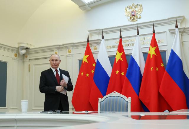 In this pool photograph distributed by the Russian state agency Sputnik, Russia's President Vladimir Putin is pictured prior to a video call with Chinese President in Moscow on February 4, 2026. (Photo by Vyacheslav PROKOFYEV / POOL / AFP)