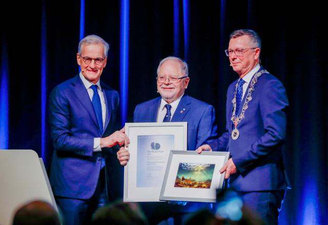 Canadian ecologist John Smol (C) of Queen's University in Canada receives the Mohn Prize for Outstanding Research Related to the Arctic 2026 from Norway's Prime Minister Jonas Gahr Store (L) and Rector of UiT The Arctic University of Norway, Dag Rune Olsen, at Arctic Frontiers conference in Tromso, on February 4, 2026. Smol, who works at Queen's University in Canada, receives the prize for his role in identifying factors driving environmental changes in the Arctic (Photo by Rune Stoltz Bertinussen / NTB / AFP) / Norway OUT