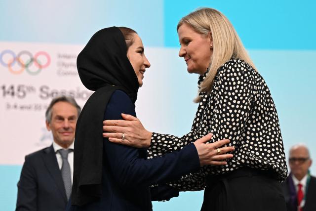 Iranian badminton player Soraya Aghaei Hajiagha (L) is greeted by International Olympic Committee (IOC) President Kirsty Coventry during her oath ceremony as the newly appointed member of IOC at the 145th IOC session ahead of the Milano Cortina 2026 Winter Olympic Games, in Milan on February 4, 2026. (Photo by Piero CRUCIATTI / AFP)