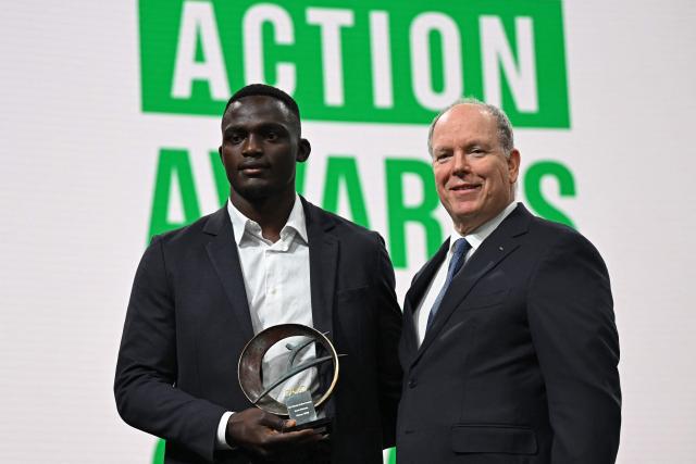 Kenya's rugby player Kevin Wekesa (L) receives the award by Prince Albert II of Monaco during the announcement of the winners of Climate Action Awards 2025 by International Olympic Committee (IOC) ahead of the Milano Cortina 2026 Winter Olympic Games, in Milan on February 4, 2026. (Photo by Piero CRUCIATTI / AFP)