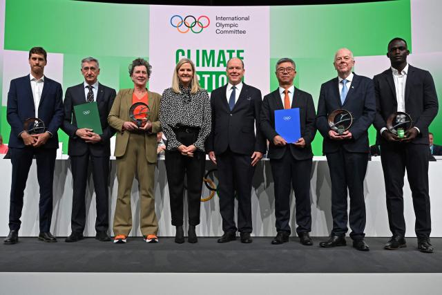 Prince Albert II (4R) of Monaco and International Olympic Committee (IOC) President Kirsty Coventry (4L) pose with the awardees during the announcement of the winners of Climate Action Awards 2025 by International Olympic Committee (IOC) ahead of the Milano Cortina 2026 Winter Olympic Games, in Milan on February 4, 2026. (Photo by PIERO CRUCIATTI / AFP)