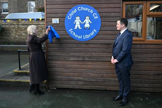 Britain's Queen Camilla (L) unveils a new plaque as she attends the opening of a library at Christ Church Primary School in London on February 4, 2026, to help mark the "National Year of Reading" and meet with pupil librarians. (Photo by JUSTIN TALLIS / POOL / AFP)