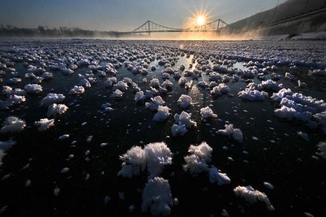 This photograph shows so called I?y Flowers on the frozen Dnipro River during sunrise in Kyiv on February 4, 2026. (Photo by Sergei SUPINSKY / AFP)