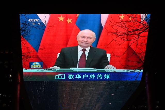 Russian President Vladimir Putin is seen during news coverage about a video call between Putin and Chinese President Xi Jinping, on a giant screen outside a shopping mall in Beijing on February 4, 2026. Putin hailed Moscow's economic, political and security ties with Beijing as a "stabilising" factor in turbulent times globally, in a video call with China's Xi on February 4. (Photo by GREG BAKER / AFP)