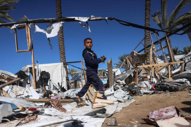 TOPSHOT - A boy makes his way through debris following a reported Israeli strike on a camp housing displaced Palestinians in Khan Yunis in the southern Gaza Strip on February 4, 2026. Despite a US-brokered truce entering its second phase last month, violence has continued in the Gaza Strip, with Israel and Hamas accusing each other of breaching the agreement. (Photo by Bashar Taleb / AFP)