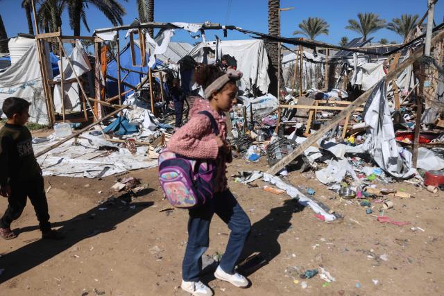 A girl walks past destroyed shelters following a reported Israeli strike on a camp housing displaced Palestinians in Khan Yunis in the southern Gaza Strip on February 4, 2026. Despite a US-brokered truce entering its second phase last month, violence has continued in the Gaza Strip, with Israel and Hamas accusing each other of breaching the agreement. (Photo by Bashar Taleb / AFP)