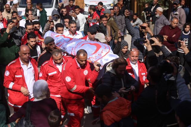 Members of the Palestinian Red Crescent carry the body of a colleague who was reportedly killed in an Israeli strike on a camp housing displaced Palestinians, during the funeral in Khan Yunis in the southern Gaza Strip on February 4, 2026. Gazan health officials said Israeli air strikes on February 4, killed 21 people in the Palestinian territory, with Israel's military saying it struck after gunfire targeting its troops wounded an officer. Despite a US-brokered truce entering its second phase last month, violence has continued in the Gaza Strip, with Israel and Hamas accusing each other of breaching the agreement. (Photo by Bashar Taleb / AFP)