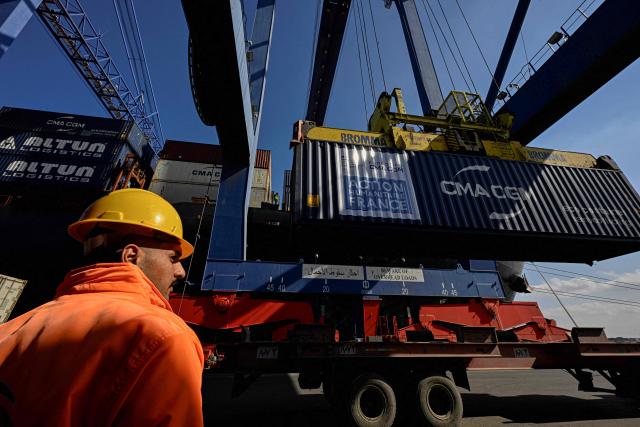 An Egyptian docker stands next to a container of French humanitarian aid for Gaza being unloaded from the commercial ship CMA CGM Tokyo docked at the port of Port Said on February 4, 2026. Israel partly reopened the Rafah crossing between Gaza and Egypt on February 2, 2026. The crossing, which is Gaza's only gateway to the outside world that does not lead to Israel, had been largely closed since Israeli forces seized control of it in May 2024 during the war with Hamas. (Photo by Khaled DESOUKI / AFP)