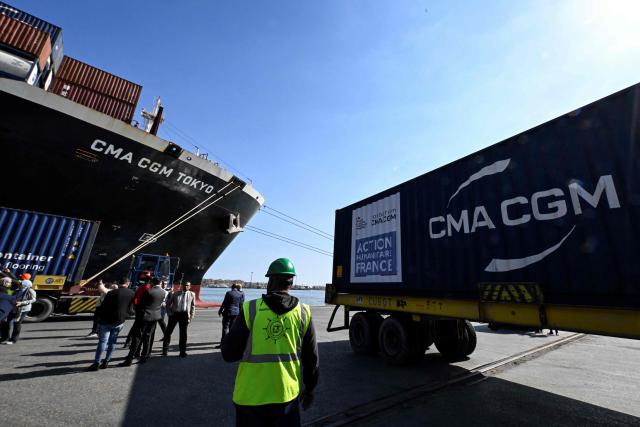 An Egyptian docker stands next to a container of French humanitarian aid for Gaza that was unloaded from the commercial ship CMA CGM Tokyo docked at the port of Port Said on February 4, 2026. Israel partly reopened the Rafah crossing between Gaza and Egypt on February 2, 2026. The crossing, which is Gaza's only gateway to the outside world that does not lead to Israel, had been largely closed since Israeli forces seized control of it in May 2024 during the war with Hamas. (Photo by Khaled DESOUKI / AFP)