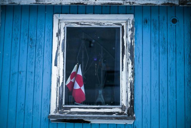A flag of Greenland is seen at a window of a house in the city of Nuuk, western Greenland, on February 4, 2026. (Photo by Ina FASSBENDER / AFP)