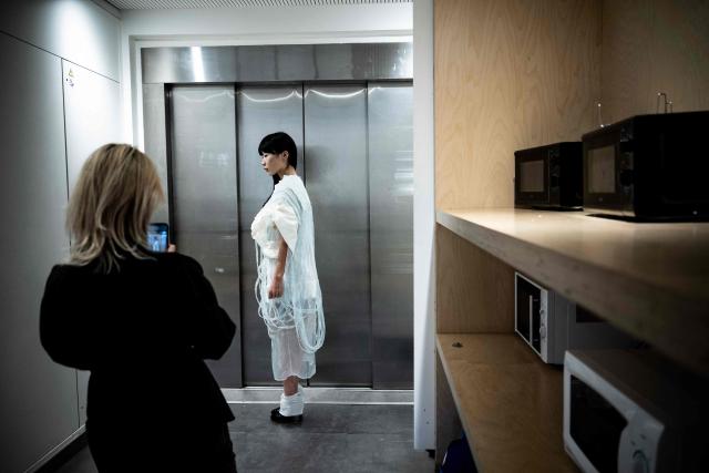 A fashion student takes a photo of a model for her undergraduate project at the Institut Francais de la Mode in Paris, on January 27, 2026. The Institut Francais de la Mode is one of the world's leading fashion schools, training students from around the globe in the fields of design, management, and craftsmanship. (Photo by JULIEN DE ROSA / AFP)