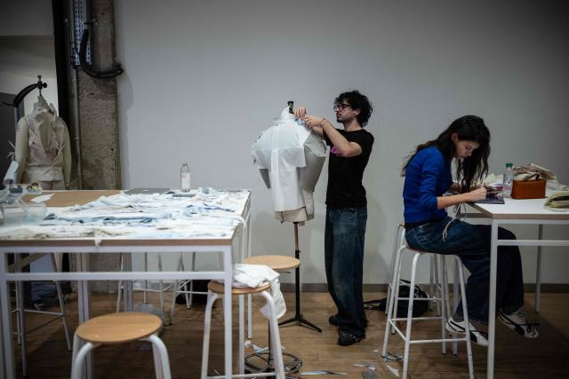 Fashions students work on their fashion project in a classroom at the Institut Francais de la Mode in Paris on January 27, 2026. The Institut Francais de la Mode is one of the world's leading fashion schools, training students from around the globe in the fields of design, management, and craftsmanship. (Photo by JULIEN DE ROSA / AFP)