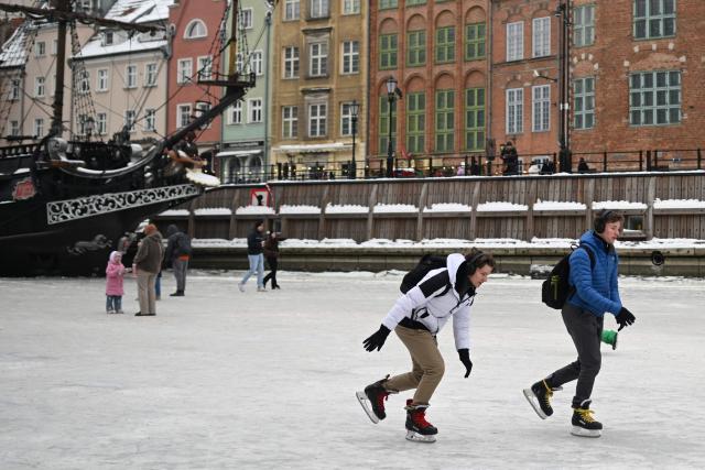 People skate on the frozen Motlawa River in central Gdansk on February 4, 2026. (Photo by Sergei GAPON / AFP)
