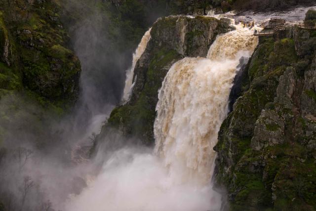This picture shows the Uces River's 'Pozo de los Humos' waterfall (Well of Smoke) which is seeing an extraordinarily high flow due to snowmelt and heavy rains affecting the country, on February 4, 2026 near Masueco in the province of Salamanca. A storm bringing what weather forecasters called "extraordinary" rain battered the Iberian peninsula today, forcing thousands of people in southern Spain from their homes, shutting schools and cancelling trains. Spanish weather agency AEMET placed parts of the southern region of Andalusia under the highest red alert for torrential rain, warning that Storm Leonardo risked triggering floods and landslides. (Photo by CESAR MANSO / AFP)