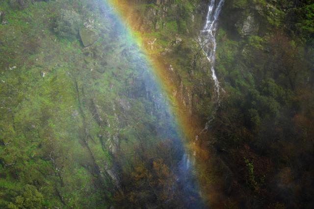 A waterfall rainbow is pictured in the area of the Uces River's 'Pozo de los Humos' waterfall (Well of Smoke) which is seeing an extraordinarily high flow due to snowmelt and heavy rains affecting the country, on February 4, 2026 near Masueco in the province of Salamanca. A storm bringing what weather forecasters called "extraordinary" rain battered the Iberian peninsula today, forcing thousands of people in southern Spain from their homes, shutting schools and cancelling trains. Spanish weather agency AEMET placed parts of the southern region of Andalusia under the highest red alert for torrential rain, warning that Storm Leonardo risked triggering floods and landslides. (Photo by CESAR MANSO / AFP)