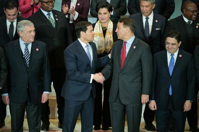 US Secretary of State Marco Rubio shakes hands with Polish Foreign Minister Radoslaw Sikorski (2R) as they participate in a family photo with invited officials during the inaugural Critical Minerals Ministerial meeting at the Sate Department in Washington, DC, on February 4, 2026. (Photo by Oliver Contreras / AFP)
