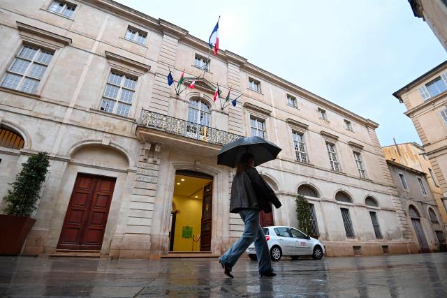 A pedestrian walks past the Nimes city hall in Nimes, southern France on February 4, 2026. (Photo by Sylvain THOMAS / AFP)