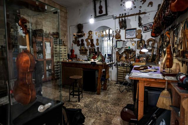 Palestinian musical instrument maker Shehada Shalalda carves the base of a violin under construction at his workshop in Ramallah in the occupied West Bank on February 4, 2026. (Photo by Zain JAAFAR / AFP)