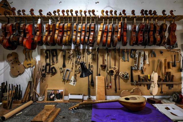 Musical instruments are pictured hanging at the workshop of Palestinian musical instrument maker Shehada Shalalda in Ramallah in the occupied West Bank on February 4, 2026. (Photo by Zain JAAFAR / AFP)