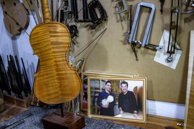 A photograph depicting Palestinian musical instrument maker Shehada Shalalda posing with Angers-based French master Patrick Robin-luthier is displayed at the former's workshop in Ramallah in the occupied West Bank on February 4, 2026. (Photo by Zain JAAFAR / AFP)