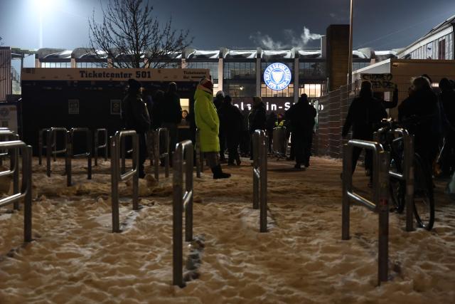 Fans are seen about to enter to the Holstein-Stadium with snow covered ground is seen on a freezing cold evening prior to the start of the German Cup (DFB-Pokal) quartefinal football match between Holstein Kiel and VfB Stuttgart in Kiel, northern Germany on February 4, 2026. (Photo by Ibrahim OT / AFP) / DFB REGULATIONS PROHIBIT ANY USE OF PHOTOGRAPHS AS IMAGE SEQUENCES AND QUASI-VIDEO.