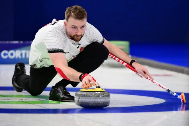 Switzerland's Yannick Schwaller curls the stone as he competes in the curling mixed doubles round robin between Estonia and Switzerland during the Milano Cortina 2026 Winter Olympic Games at the Cortina Curling Olympic Stadium in Cortina d’Ampezzo on February 4, 2026. (Photo by Marco BERTORELLO / AFP)