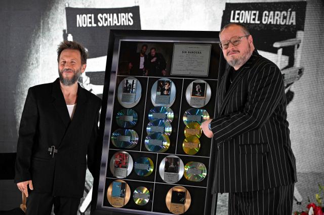 Noel Schajris (L) and Leonel Garcia of the Mexican musical duo Sin Bandera pose with an award from their record label Sony for their previous albums during the presentation of their latest album, titled "Escenas", at the St. Regis Hotel in Mexico City on February 4, 2026. (Photo by Alfredo ESTRELLA / AFP)