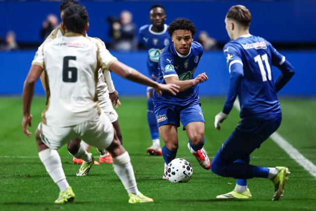 Troyes' French defender #03 Noah Donkor (C) fights for the ball during the French Cup round of 16 football match between Estac Troyes and Lens RC at the Stade de l'Aube in Troyes on February 4, 2026. (Photo by Sameer Al-DOUMY / AFP)