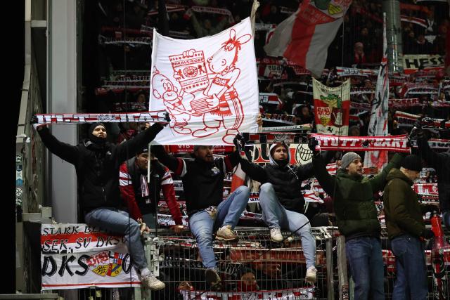 Stuttgart fans cheer for their team during the German Cup (DFB-Pokal) quartefinal football match between Holstein Kiel and VfB Stuttgart in Kiel, northern Germany on February 4, 2026. (Photo by Ibrahim OT / AFP) / DFB REGULATIONS PROHIBIT ANY USE OF PHOTOGRAPHS AS IMAGE SEQUENCES AND QUASI-VIDEO.