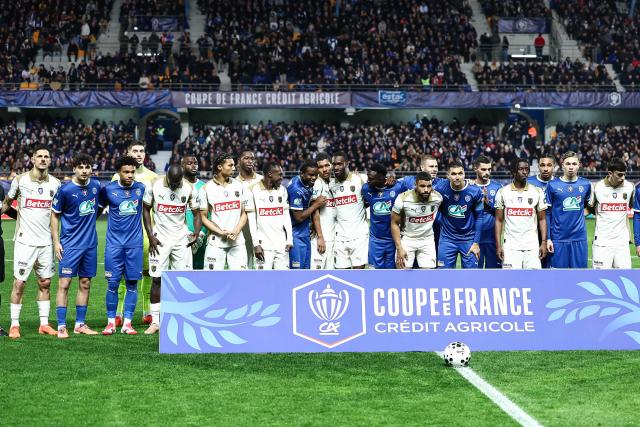 Lens' players and Troyes' players line up ahead of the French Cup round of 16 football match between Estac Troyes and Lens RC at the Stade de l'Aube in Troyes on February 4, 2026. (Photo by Sameer Al-DOUMY / AFP)