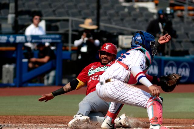 Federales de Chiriqui’s #7 Johan Camargo dives toward home plate as Leones del Escogido’s #25 Michael De La Cruz catches the ball during the third inning of the Caribbean Series baseball tournament seventh game between Panama's Federales de Chiriqui and Dominican Republic's Leones del Escogido at the Panamerican Stadium in Jalisco, Mexico, on February 4, 2026. (Photo by Ulises Ruiz / AFP)